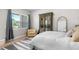 Bright bedroom with large window, accent wall, and wooden floors at 6317 Rivo Lakes Blvd, Sarasota, FL 34241