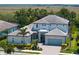 Elegant two-story home with a well-manicured lawn and lush landscaping, complete with a driveway leading to a two-car garage at 6317 Rivo Lakes Blvd, Sarasota, FL 34241