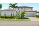 Charming two-story home features a well-kept lawn, mature landscaping, and a convenient two-car garage at 6317 Rivo Lakes Blvd, Sarasota, FL 34241