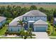 Two-story home boasts a meticulously landscaped front yard and a covered entrance, enhancing its curb appeal at 6317 Rivo Lakes Blvd, Sarasota, FL 34241