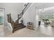 Open foyer features wood-look tile, a staircase with iron railing, and a glimpse into a spacious living area at 6317 Rivo Lakes Blvd, Sarasota, FL 34241