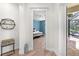 Hallway view of a bedroom with a ceiling fan and a sliding glass door that reveals a patio with chairs at 6317 Rivo Lakes Blvd, Sarasota, FL 34241