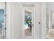 Bright hallway providing a glimpse of a screened patio with a dining area and pool at 6317 Rivo Lakes Blvd, Sarasota, FL 34241