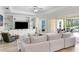 Bright living room with a custom built-in wall unit and sliding glass doors to screened patio at 6317 Rivo Lakes Blvd, Sarasota, FL 34241