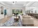 Bright living room flows to outdoor dining area and pool; boasts built-ins, tray ceilings and abundant natural light at 6317 Rivo Lakes Blvd, Sarasota, FL 34241
