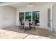 The covered patio boasts stone flooring and a dining table with chairs under a ceiling fan at 6317 Rivo Lakes Blvd, Sarasota, FL 34241