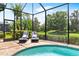 Relaxing poolside view with comfortable lounge chairs and lush greenery beyond the screen at 6317 Rivo Lakes Blvd, Sarasota, FL 34241