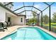 Inviting pool area with a covered lanai, surrounded by tropical landscaping and lush greenery at 6317 Rivo Lakes Blvd, Sarasota, FL 34241