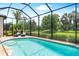 Sparkling pool area with a screen enclosure and serene views of the landscaped backyard at 6317 Rivo Lakes Blvd, Sarasota, FL 34241