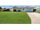 Charming single-story home boasts a well-manicured front lawn and cheerful curb appeal with a blue front door and matching garage at 7301 12Th W Ave, Bradenton, FL 34209