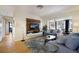 Comfortable living area features modern entertainment center, hardwood floors, and a view into the dining area at 7301 12Th W Ave, Bradenton, FL 34209