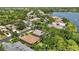 An aerial view displays a neighborhood with lush green trees and a serene lake at 7439 Sea Island Ln, University Park, FL 34201