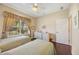 Sunlit bedroom features hardwood floors, two twin beds and a window with decorative curtains at 7439 Sea Island Ln, University Park, FL 34201