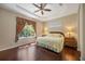Serene bedroom showcases tray ceiling, wood floors, and a large window with natural light at 7439 Sea Island Ln, University Park, FL 34201