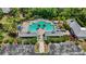An aerial shot shows the community pool with covered seating, surrounded by lush trees at 7439 Sea Island Ln, University Park, FL 34201