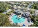 Aerial view of a luxurious community pool, cabanas, and lush tropical landscaping at 7439 Sea Island Ln, University Park, FL 34201