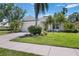 Charming single-story home featuring a well-manicured lawn, lush tropical landscaping, and an attached two-car garage at 7439 Sea Island Ln, University Park, FL 34201