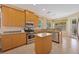 Well-equipped kitchen featuring stainless appliances, granite countertops, island and light wood cabinets at 7439 Sea Island Ln, University Park, FL 34201