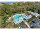 Aerial view of a vibrant community pool with lounging areas, surrounded by lush trees at 7439 Sea Island Ln, University Park, FL 34201