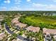 An elevated view of a neighborhood with manicured landscaping, a pond, and verdant foliage at 7470 Botanica Pkwy # 201B22, Sarasota, FL 34238
