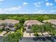 Elevated view of residences, lush greenery, and a tranquil lake, showcasing the neighborhood's landscape at 7470 Botanica Pkwy # 201B22, Sarasota, FL 34238