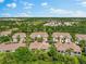 An aerial view showcasing a neighborhood's terracotta roofs, lush foliage, and serene ponds at 7470 Botanica Pkwy # 201B22, Sarasota, FL 34238