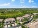 An aerial view of the neighborhood, highlighting lush landscaping, ponds, and terra cotta tile roofs at 7470 Botanica Pkwy # 201B22, Sarasota, FL 34238