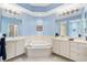 Light-filled bathroom featuring dual sinks, a bathtub, blue accents, and ample counter space at 7470 Botanica Pkwy # 201B22, Sarasota, FL 34238