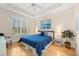 Bright bedroom with a tray ceiling, shuttered windows, hardwood floors, and comfortable décor at 7470 Botanica Pkwy # 201B22, Sarasota, FL 34238