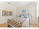 Cozy bedroom with a decorative quilt, matching lamps, and natural light at 7470 Botanica Pkwy # 201B22, Sarasota, FL 34238