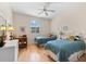 Bright, cozy bedroom with two twin beds, a desk, and shuttered windows at 7470 Botanica Pkwy # 201B22, Sarasota, FL 34238