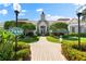 Beautiful clubhouse featuring a charming brick walkway, lush landscaping, and distinctive architectural details at 7470 Botanica Pkwy # 201B22, Sarasota, FL 34238