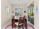 Charming dining room with a dark wood table set for six, elegant chandelier, and sliding glass doors to lanai at 7470 Botanica Pkwy # 201B22, Sarasota, FL 34238