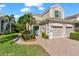 Beautiful exterior with a well-maintained lawn, lush landscaping, and a brick walkway leading to the front door at 7470 Botanica Pkwy # 201B22, Sarasota, FL 34238