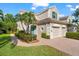 Beautiful exterior with a well-maintained lawn, lush landscaping, and a brick walkway leading to the front door at 7470 Botanica Pkwy # 201B22, Sarasota, FL 34238