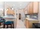 Kitchen view with wooden cabinets, white appliances, and eat-in bar at 7470 Botanica Pkwy # 201B22, Sarasota, FL 34238