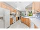 Bright kitchen featuring white appliances, wooden cabinets, and tiled floors at 7470 Botanica Pkwy # 201B22, Sarasota, FL 34238