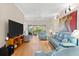 Spacious living room with a large TV, access to the balcony, and an open floorplan at 7470 Botanica Pkwy # 201B22, Sarasota, FL 34238