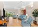 Bright living room with balcony, light blue seating, hardwood floors, and ceiling fan at 7470 Botanica Pkwy # 201B22, Sarasota, FL 34238