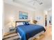 Comfortable main bedroom featuring a tray ceiling, hardwood floors, shuttered windows, and an ensuite bathroom at 7470 Botanica Pkwy # 201B22, Sarasota, FL 34238