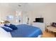 Cozy main bedroom showcasing a tray ceiling, TV, ensuite bathroom, and comfortable furniture at 7470 Botanica Pkwy # 201B22, Sarasota, FL 34238