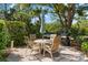 A relaxing outdoor patio with seating, grilling area, and lush greenery, perfect for entertaining at 7470 Botanica Pkwy # 201B22, Sarasota, FL 34238