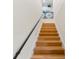 A modern staircase featuring light wood treads, a black metal handrail, and white risers at 7470 Botanica Pkwy # 201B22, Sarasota, FL 34238