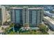 Aerial view of a condo building showcasing beautiful landscaping, pool, and lake fountain at 750 N Tamiami Trl # 304, Sarasota, FL 34236