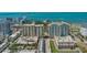 Aerial view highlighting two high-rise condo buildings near water, plus a pool and a parking garage at 750 N Tamiami Trl # 304, Sarasota, FL 34236
