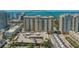 An aerial view showcases a high-rise condo building with a parking garage and a water view at 750 N Tamiami Trl # 304, Sarasota, FL 34236