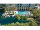 Aerial view of a pool area featuring a serene lake and lush landscaping at 750 N Tamiami Trl # 304, Sarasota, FL 34236