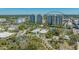 An aerial view showcasing two high-rise condo buildings surrounded by lush landscaping and city views at 750 N Tamiami Trl # 304, Sarasota, FL 34236