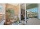 Outdoor balcony featuring seating and decor, with views into the living room through the sliding doors at 750 N Tamiami Trl # 304, Sarasota, FL 34236