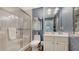 Bathroom featuring glass shower, modern vanity, and wallpapered walls at 750 N Tamiami Trl # 304, Sarasota, FL 34236